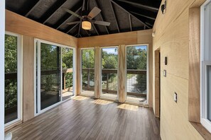 A room with large windows, a ceiling fan, and wooden flooring. - Free Ruby Falls Ticket & More-Hot Tub-Handcrafted Cabin with Tower-Lookout Mountain-Romantic Getaway (Lookout Mountain)