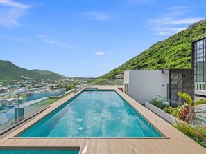 Ein Pool auf dem Dach mit Blick auf eine Stadt und Berge.