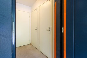 A hallway with two closed doors, one marked with the number 2, and a blue door with an orange stripe. - Diverse outdoor activities, incl. end cleaning (Rukatunturi)