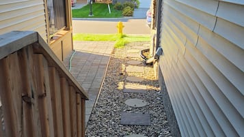 Un chemin piétonnier menant à une maison dotée d’une terrasse en bois et d’une borne d’incendie.