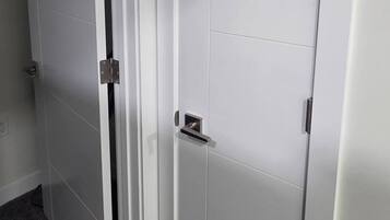 Une pièce dont la porte est fermée, avec une poignée de porte visible, et où l’on aperçoit une partie d’un sol recouvert de moquette.