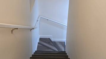 A staircase with a handrail and a dark wooden finish.