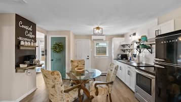 A modern kitchen with a Galanz refrigerator, a coffee station, and a dining area with patterned chairs.