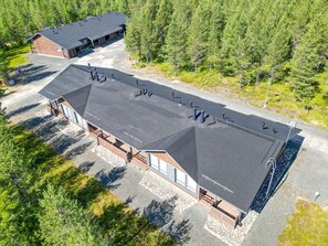 A two-story building with a sloped roof, large windows, and a paved driveway. - Activities from the front door, incl. cleaning (Rukatunturi)