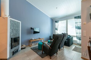A living room with a flat-screen TV, a fireplace, and a sofa. - Activities from the front door, incl. cleaning (Rukatunturi)