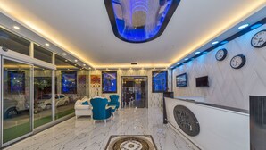 A modern lobby with a reception desk, seating area, and a decorative floor pattern. - New My World Hotel (Istanbul)