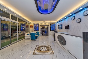 Eine moderne Lobby mit einer Rezeption, einer Sitzecke und einem dekorativen Bodenmuster.