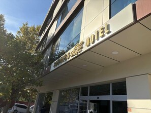 Un hotel amb una façana moderna, grans finestres i un rètol que indica que és un hotel.