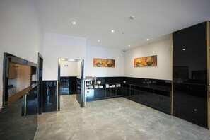 Una cuina moderna amb armaris negres, una illa central i obra d'art a les parets.