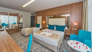 A hotel room with two beds, a sitting area, a mirror, and a bedside table. - New My World Hotel (Istanbul)