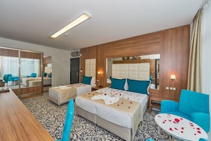 Ein Hotelzimmer mit zwei Betten, einer Sitzecke, einem Spiegel und einem Nachttisch.
