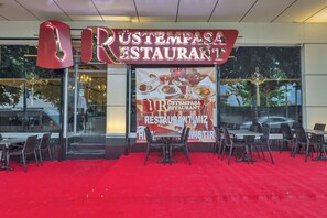 Un restaurant amb catifes vermelles i seients a l'exterior.