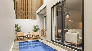 Espaço moderno ao ar livre com piscina, área de estar e vista para uma sala de estar.