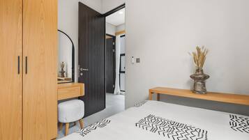 Ein modernes Schlafzimmer mit einem Holzschrank, einem Nachttisch mit einer Vase und einem Bett mit einem geometrischen Bettbezug.
