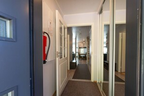 A hallway with a fire extinguisher mounted on the wall, leading to a dining area with a table and chairs. - Apartment surrounded by the nature, incl. cleaning (Rukatunturi)
