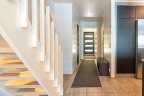 Una cocina moderna con un refrigerador de acero inoxidable, un armario de madera oscura y una encimera de color claro.
