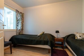 A bedroom with two single beds, a desk, and a nightstand. - Apartment surrounded by the nature, incl. cleaning (Rukatunturi)