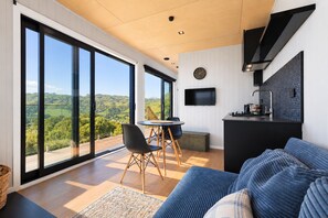 A modern kitchen with a black countertop and a flat-screen TV mounted on the wall.