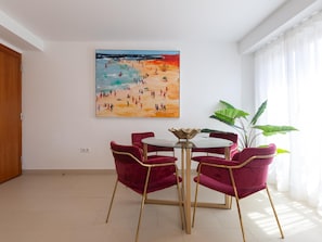 A room with a dining table, four chairs, a painting, and a plant. - Centrally located apartment with a terrace (Málaga)