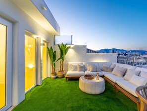 A rooftop terrace with a green artificial turf, a white sofa set, and potted plants. - Penthouse with exclusive terrace, pool, and panoramic views (Málaga)
