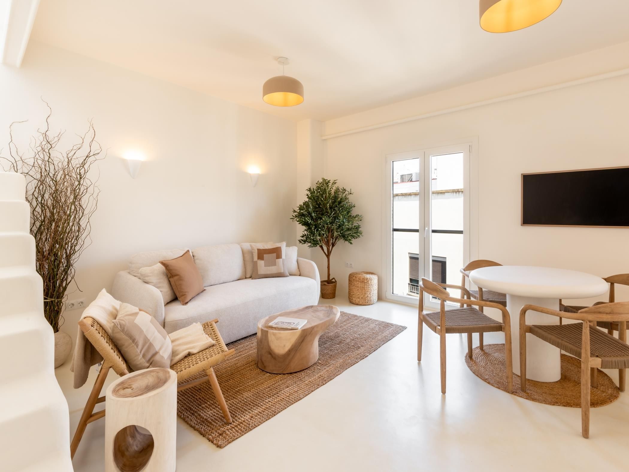 A modern living room with a sofa, coffee table, and dining area.