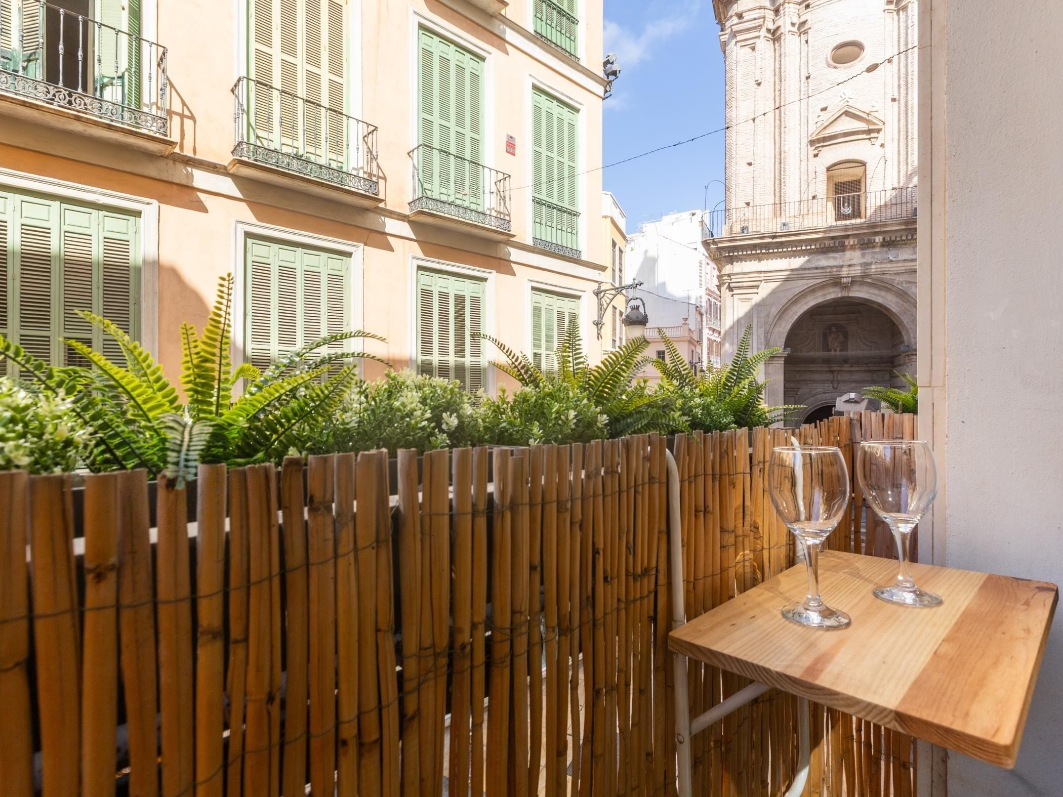 Une clôture en bois avec une table et deux verres à vin.