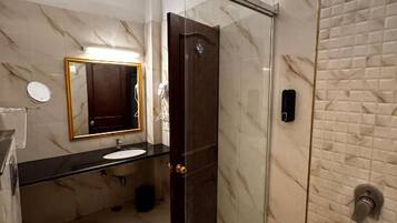 Ein modernes Badezimmer mit einer Duschkabine, Toilette, Waschbecken und Spiegel.