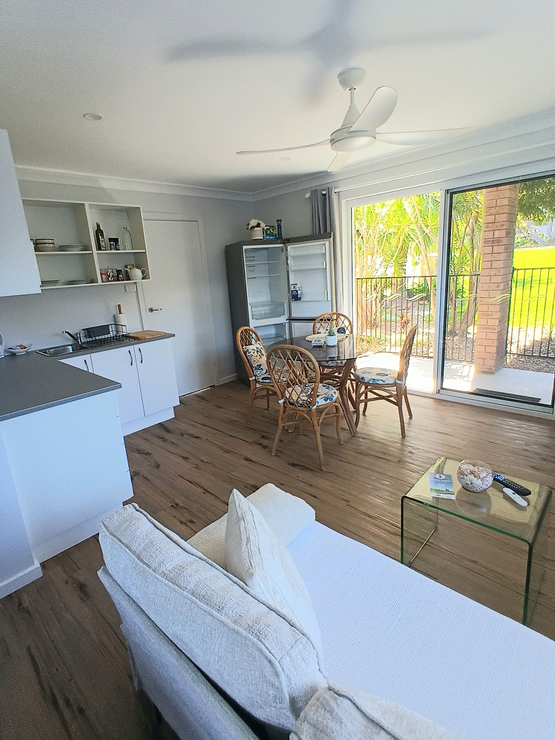 A compact living space with a kitchenette, dining area, and a sofa.