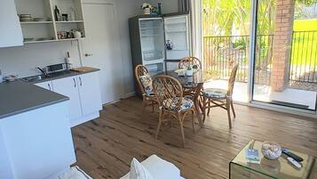 A compact living space with a kitchenette, dining area, and a sofa.