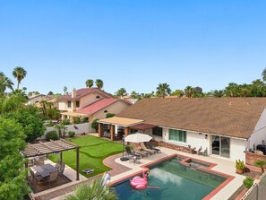 A residential area with a swimming pool, patio furniture, and a covered seating area. - 4-bedroom Retreat in Scottsdale with Heated Pool, Firepit, Putting Green/Games (Scottsdale)