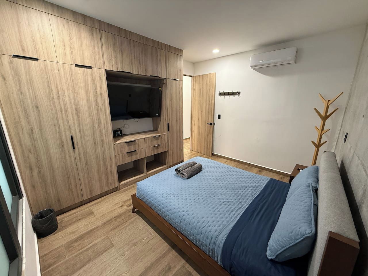 Een slaapkamer met een bed, een kledingkast en een televisie.