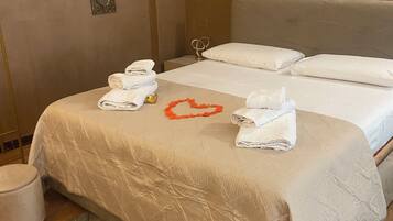 Una habitación de hotel con una cama, dos almohadas, una decoración con forma de corazón y toallas.