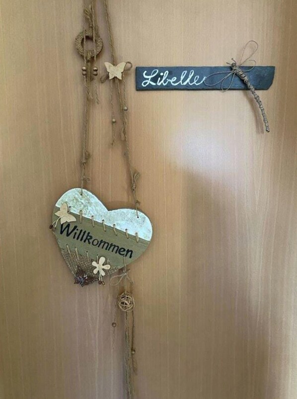 A wooden door with a heart-shaped decoration hanging on it, and a small sign with the name 'Liliette' attached to the door. - Holiday Apartment With 1 Bedroom (Lübbenau/Spreewald)