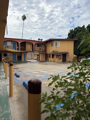 A multi-story building with a parking lot, marked handicap spaces, and a sign for 'El Naju Macan.'