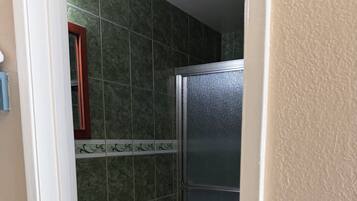 A bathroom with a toilet, a sink, and a shower enclosure.
