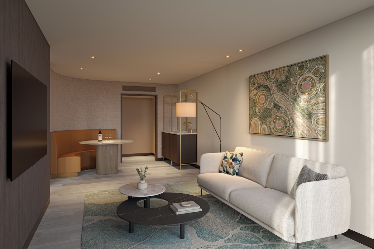 Un salon moderne avec un canapé, une table basse et un tableau accroché au mur.