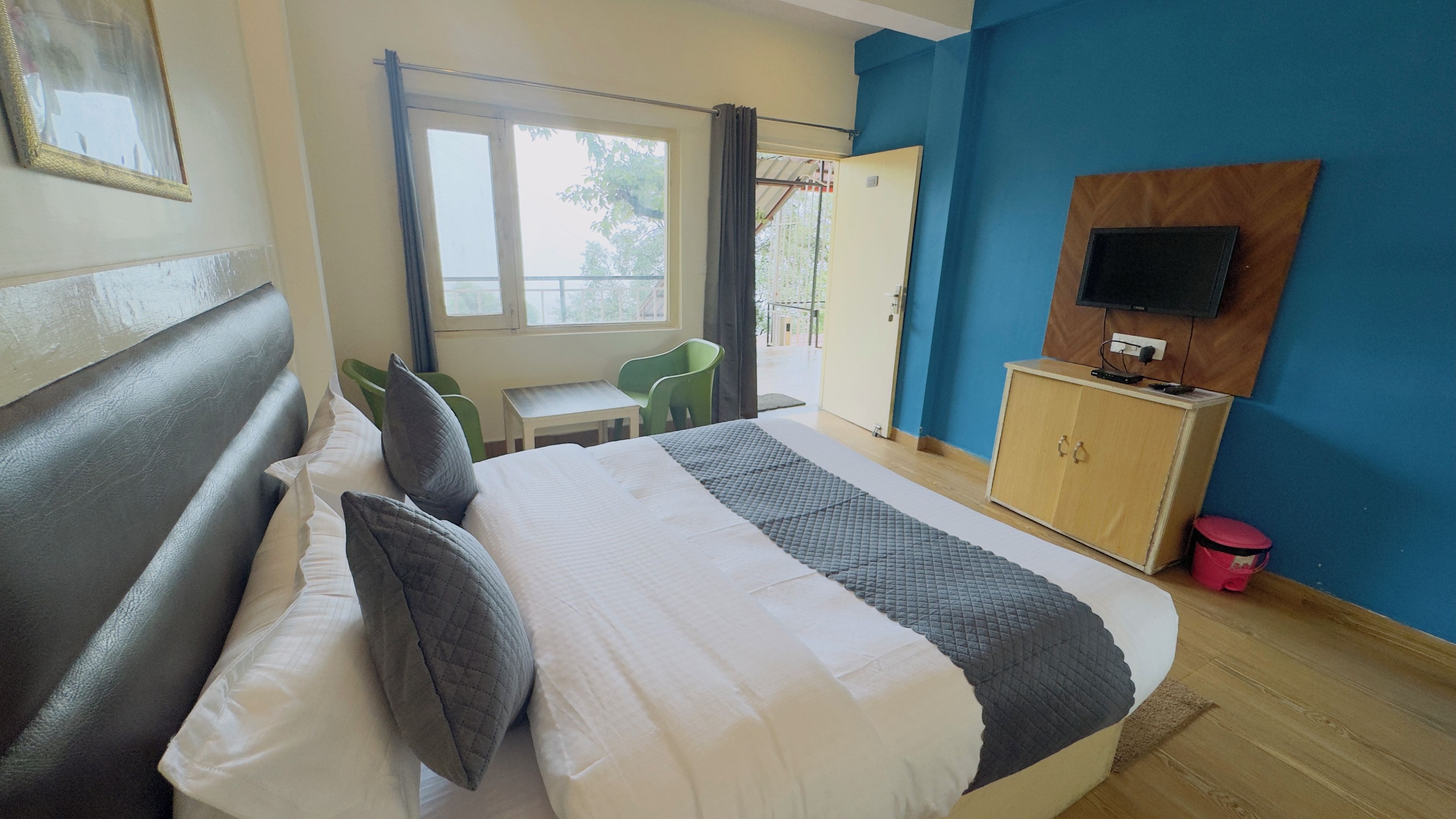 Een hotelkamer met een bed, een televisie, een klein tafeltje en een stoel.