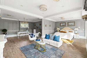Une chambre spacieuse avec un grand lit, un coin salon avec un canapé et un bureau.