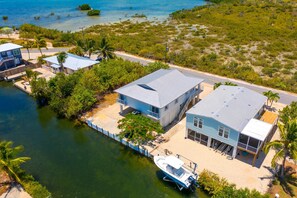 A coastal property with a house, a dock, and a boat. - Escape to Eden | Sunset Views & Dockage (Big Pine Key)