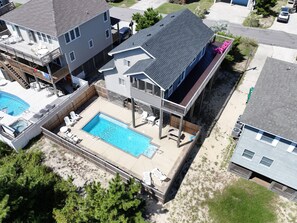 Ett bostadsområde med en swimmingpool, flera terrasser och ett garage.