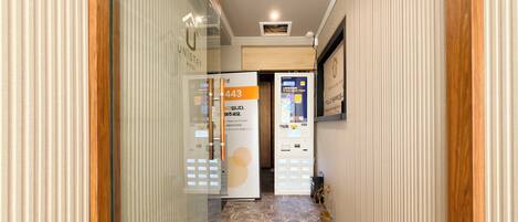A hotel corridor with a reception desk, a vending machine, and a sign with the number 443.