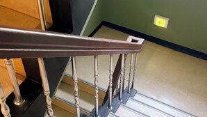 A staircase with a metal handrail and wooden steps. - Unistay (Dongducheon)