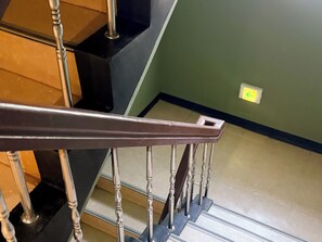 Una escalera con barandilla de metal y escalones de madera.