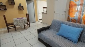 A living room with a sofa, a small table, and a chair. - Beautiful and comfortable house in Paraty. (Paraty)