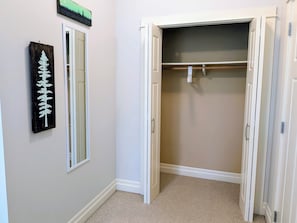 A hallway with a closet, a mirror, and a wall-mounted sign. - Bright & cozy private room near downtown Victoria (Victoria)