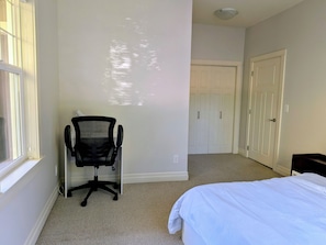 Une chambre à coucher avec un lit, une chaise, une armoire et une fenêtre.