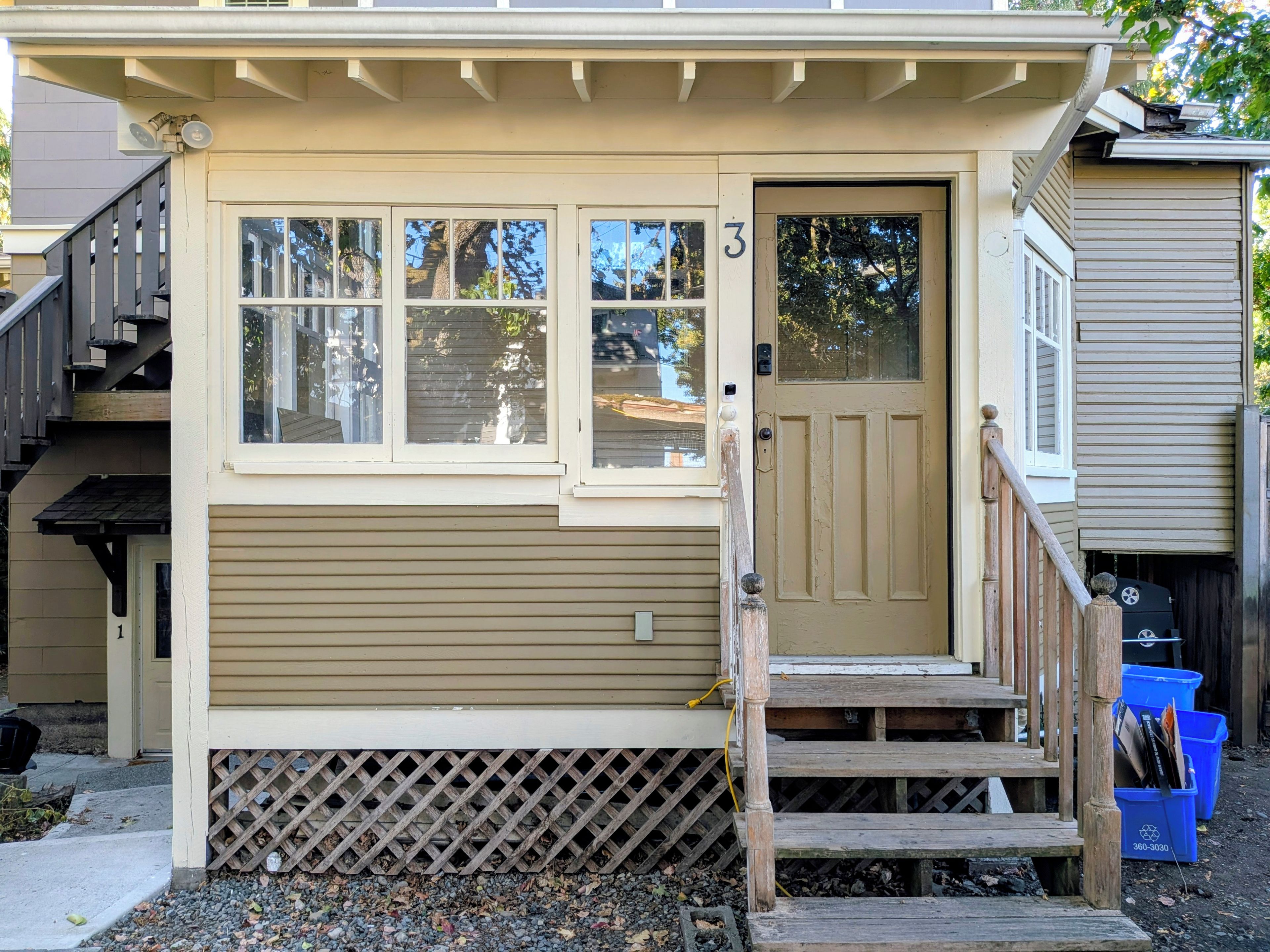 Une maison de plain-pied avec une porte d’entrée, un petit porche et un escalier menant à l’entrée.