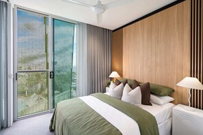 Ein modernes Schlafzimmer mit einem großen Bett, zwei Nachttischlampen, einer Schiebetür aus Glas und einem Deckenventilator.