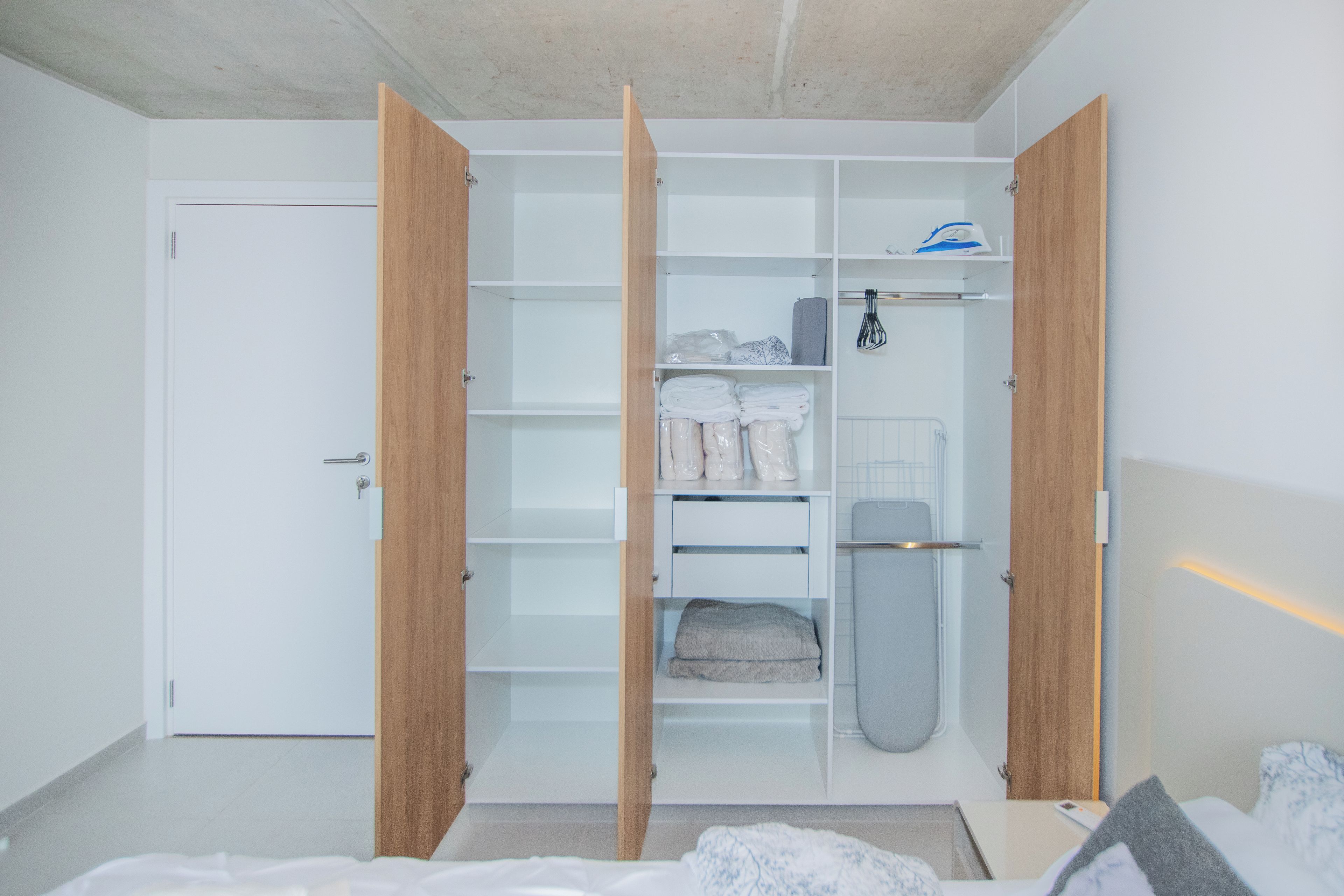 Un vestidor amplio con puertas abiertas, estantes y espacio para colgar.