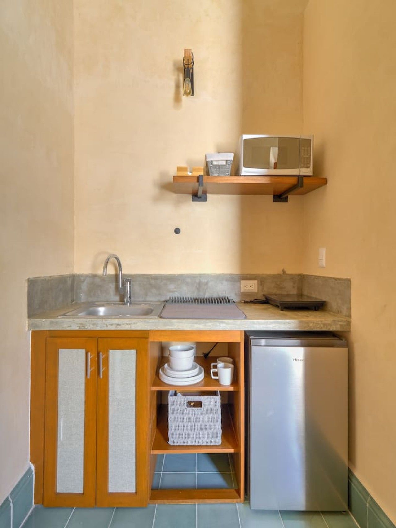 A compact kitchen with a sink, a microwave, and a refrigerator.
